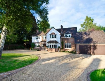 Detached home with long gravel driveway and double garage