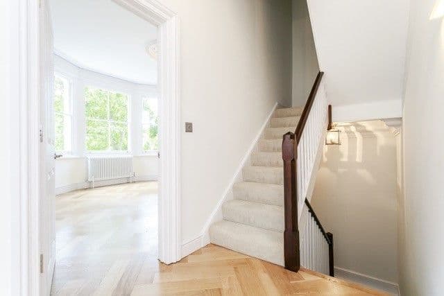Hallway and stairs looking through to front reception room