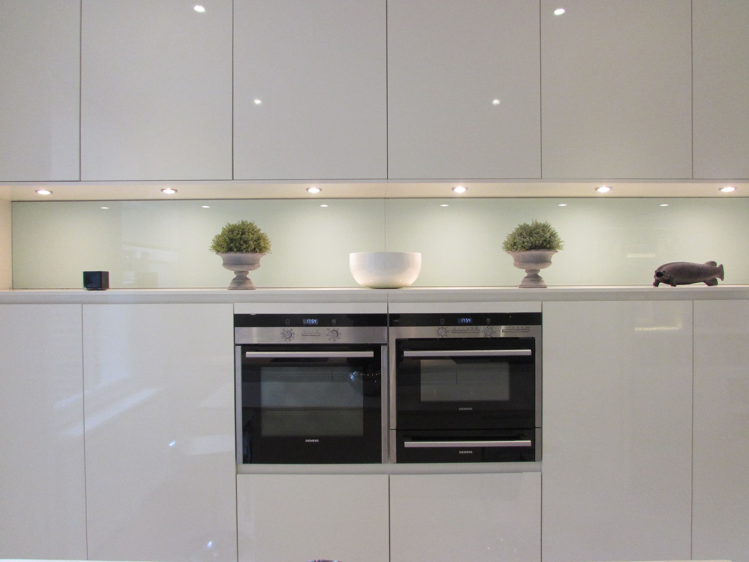 gloss kitchen units with built in appliances and ornaments