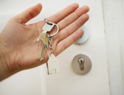 Key in hands with a door in the background